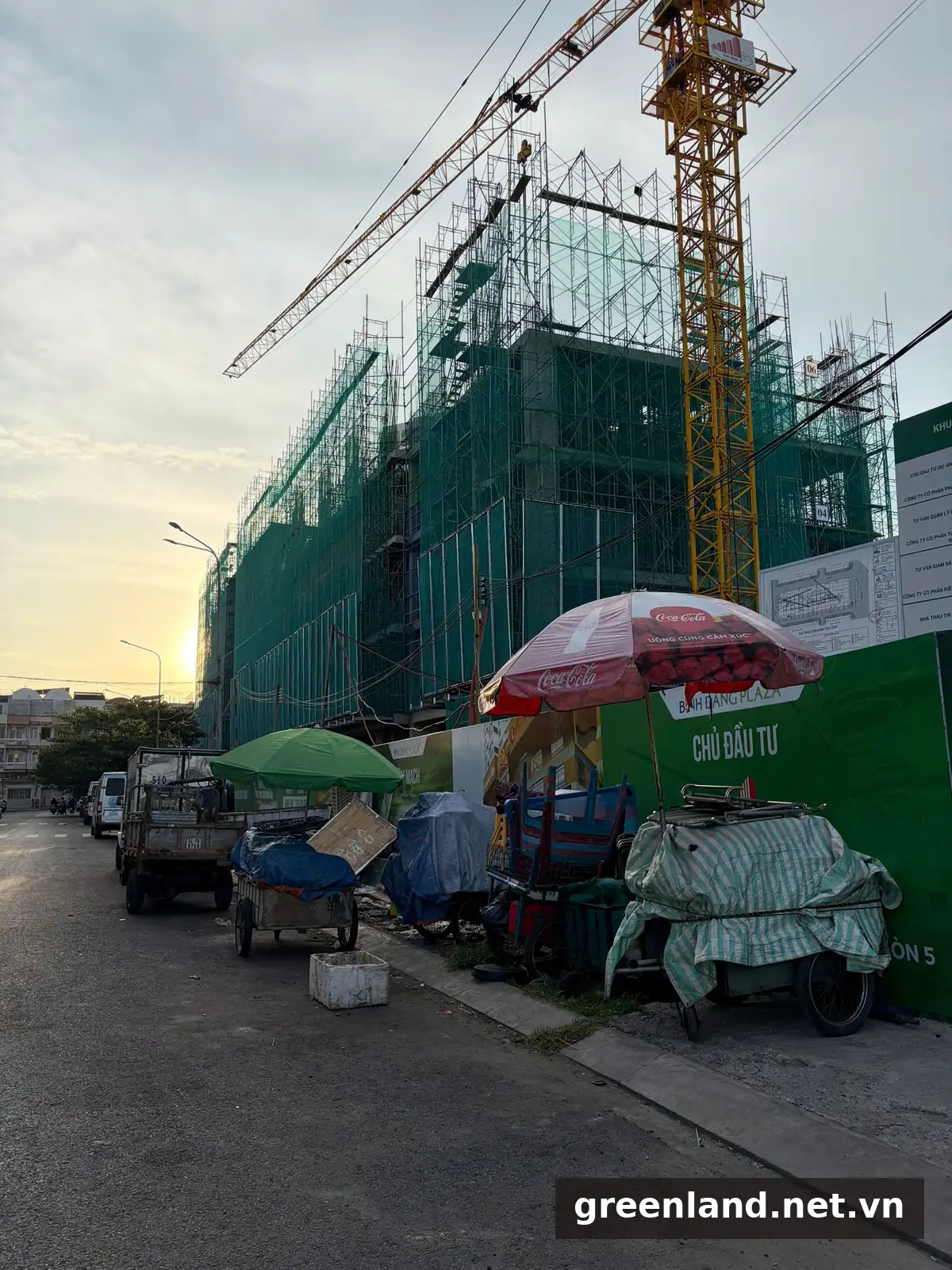 Tiến Độ Xây Dựng Bình Đăng Plaza Trên Quốc Lộ 50, Quận 8 14 Công trường Bình Đăng Plaza lúc hoàng hôn ngày 26/08/2026, bảng thông tin công trình và bản vẽ được niêm yết tại hàng rào